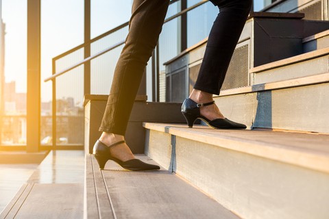 A woman in heels walks up steps