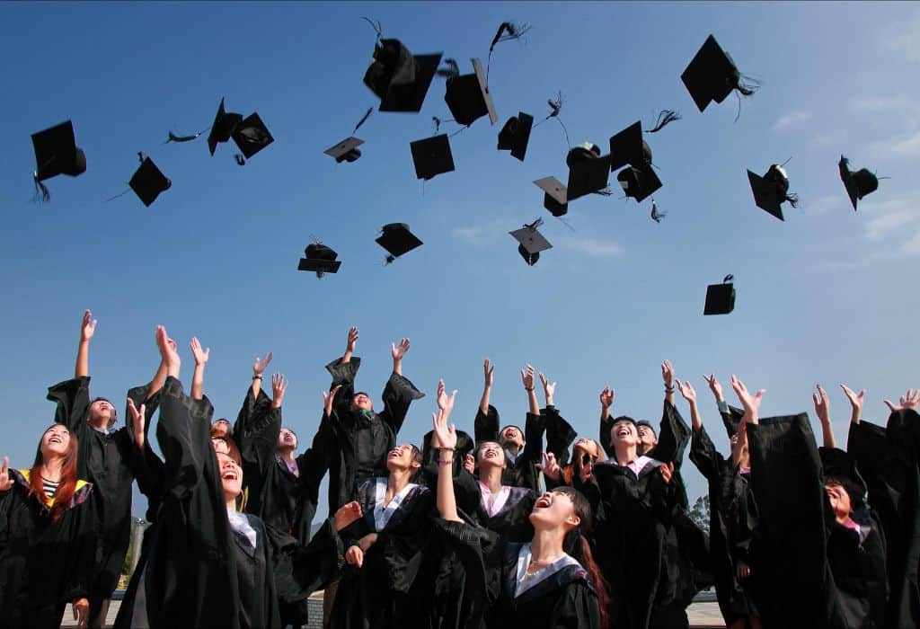 Graduates throw their caps into the air